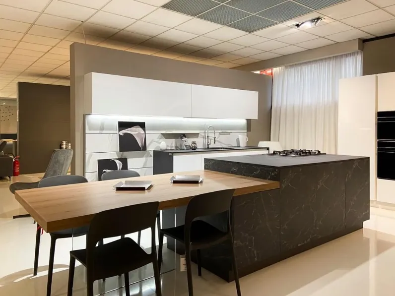 Una cucina con isola bianca con sgabelli neri e piano di lavoro bianco.