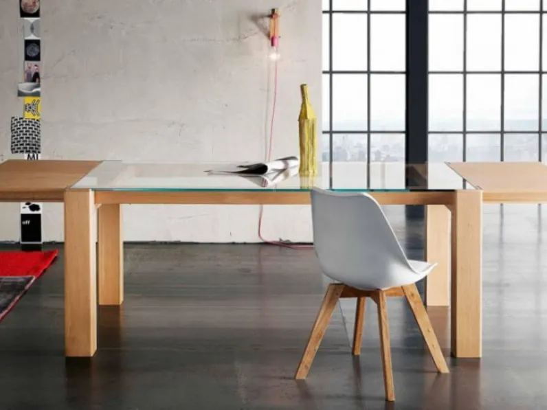 Tavolo Alta Corte modello Sidney. Il tavolo ha il piano in vetro trasparente e la struttura in legno rovere disponibile in diverse finiture.