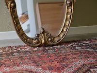 Specchiera in legno massello di Produzione Artigianale. Cornice specchiera dorata con intagli floreali e decorazioni sul lato esterno. Scontata del -53%. Offerta Outlet Mobilgross.