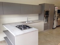 CUCINA DI MOSTRA CON BANCONE SNACK MODERNA LACCATA CEMENTO