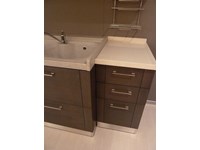 Cucina Astra modello DADA, con basi in rovere grigio e pensili in rovere poro aperto laccato bianco, a doppia profondità: 60 cm per le due basi laterali e 70 cm per la parte centrale con canale retrostante attrezzato. Top in Teknor e quarzo.