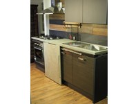 cucina moderna linea industrial con anta scorrevole top cemento essenza stone