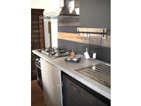 cucina moderna linea industrial con anta scorrevole top cemento essenza stone
