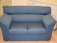 Divanetto a due posti in tessuto azzurro sfoderabile con profondità 70 cm.
